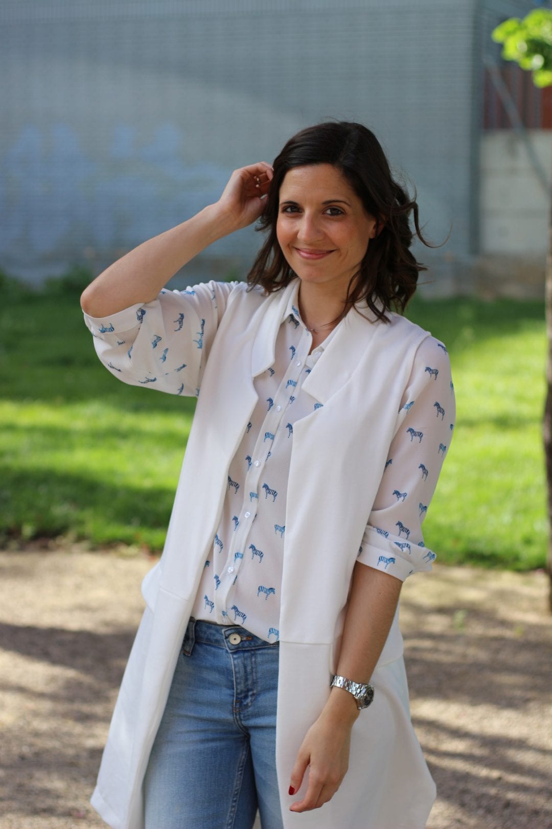 fashion blogger con look casual - chaleco blanco largo - jeans y blusa estampada